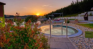 Whirlpool mit Panorama bei Sonnenuntergang Freiluft-Whirlpool im Wellnesshotel im Bayerischen Wald